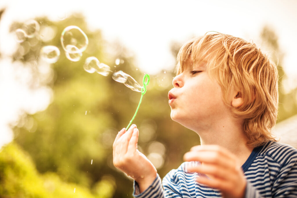 boy blowing bubbles, summer